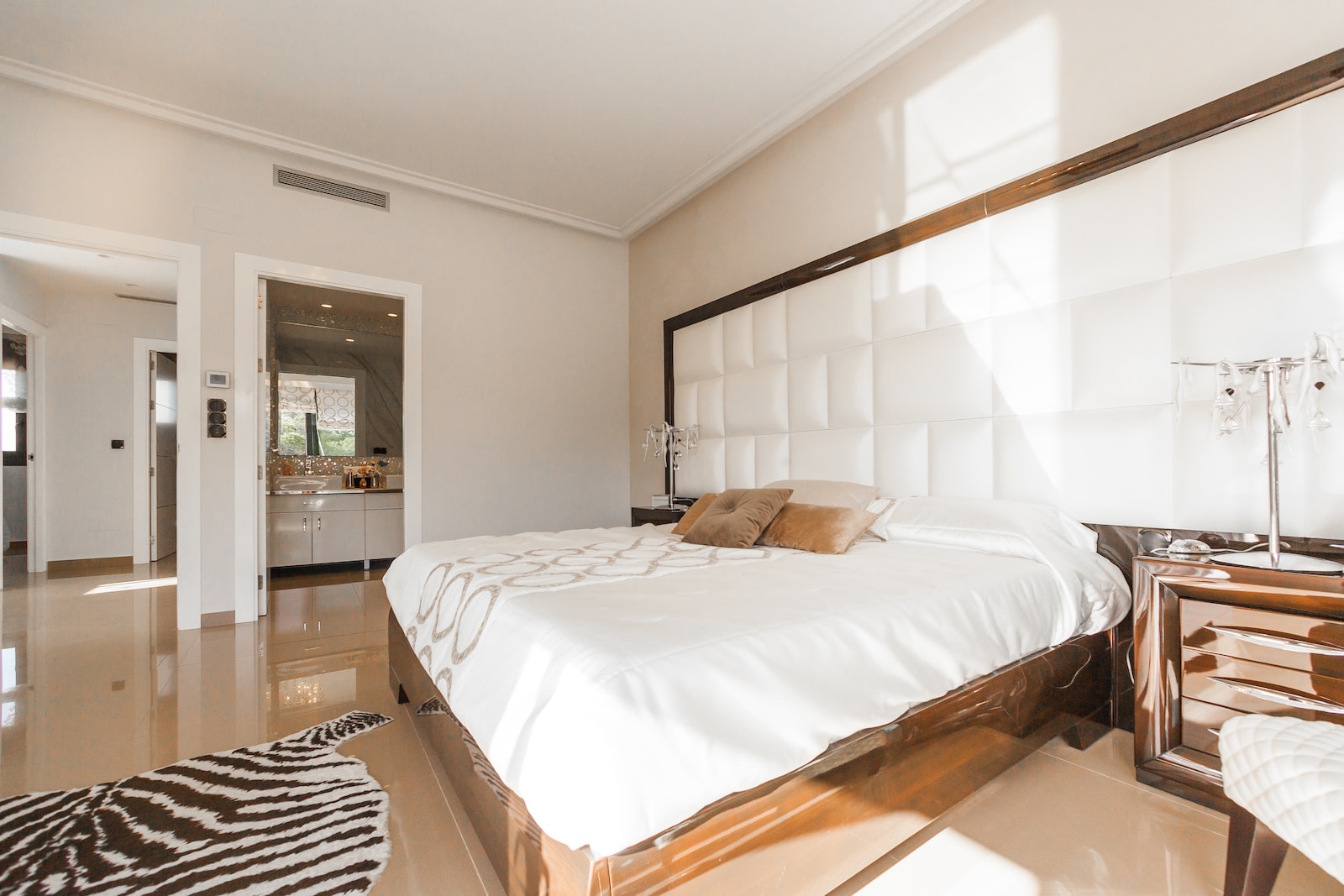 brown wooden bed frame with white cover beside brown wooden nightstand